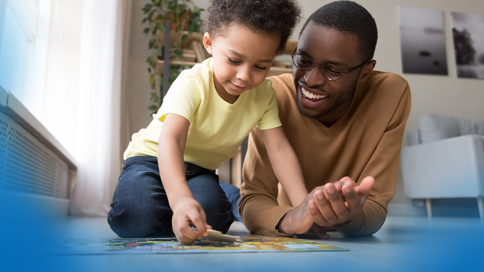 Man with his child putting together a jigsaw puzzle